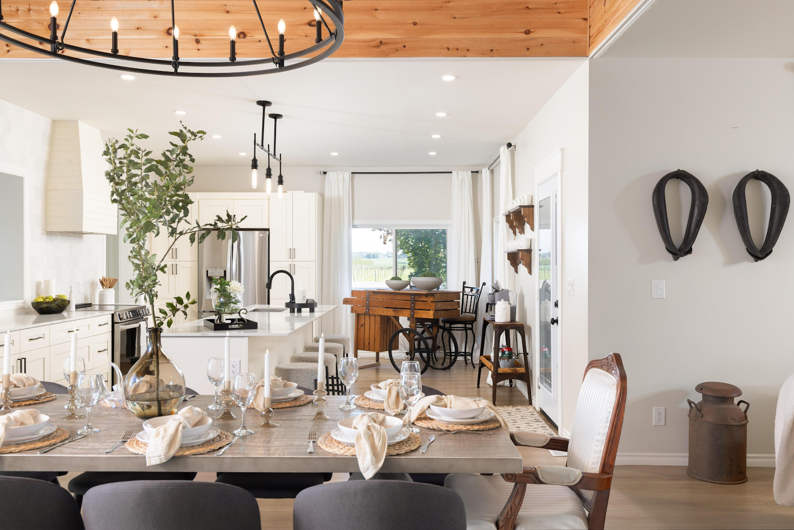 Open-plan dining and living area in The Ranch House at Sorella 1881 — set dining table with chandelier