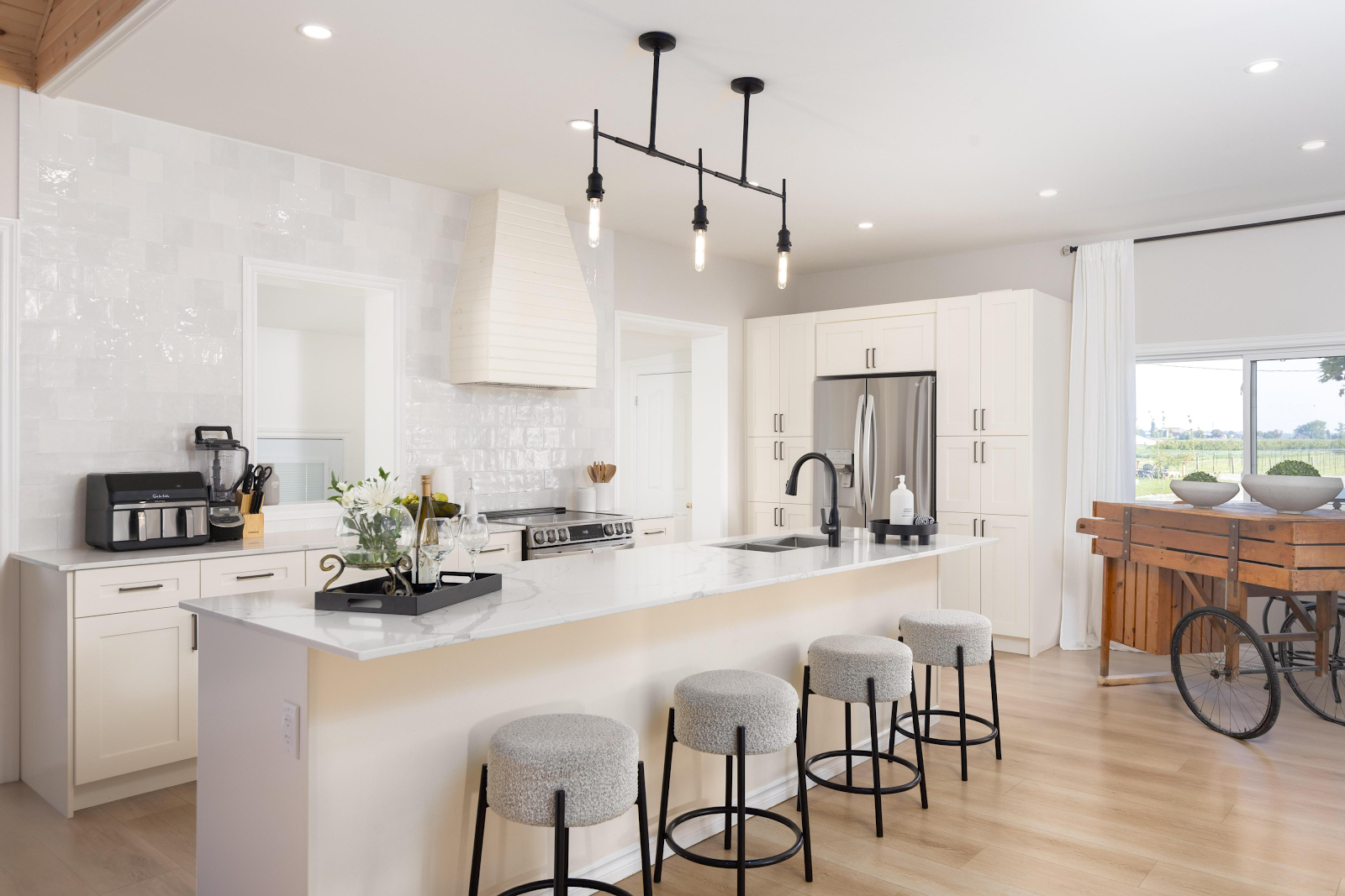 Modern white kitchen in The Ranch House at Sorella 1881 — marble island, pendant lights, farmhouse decor